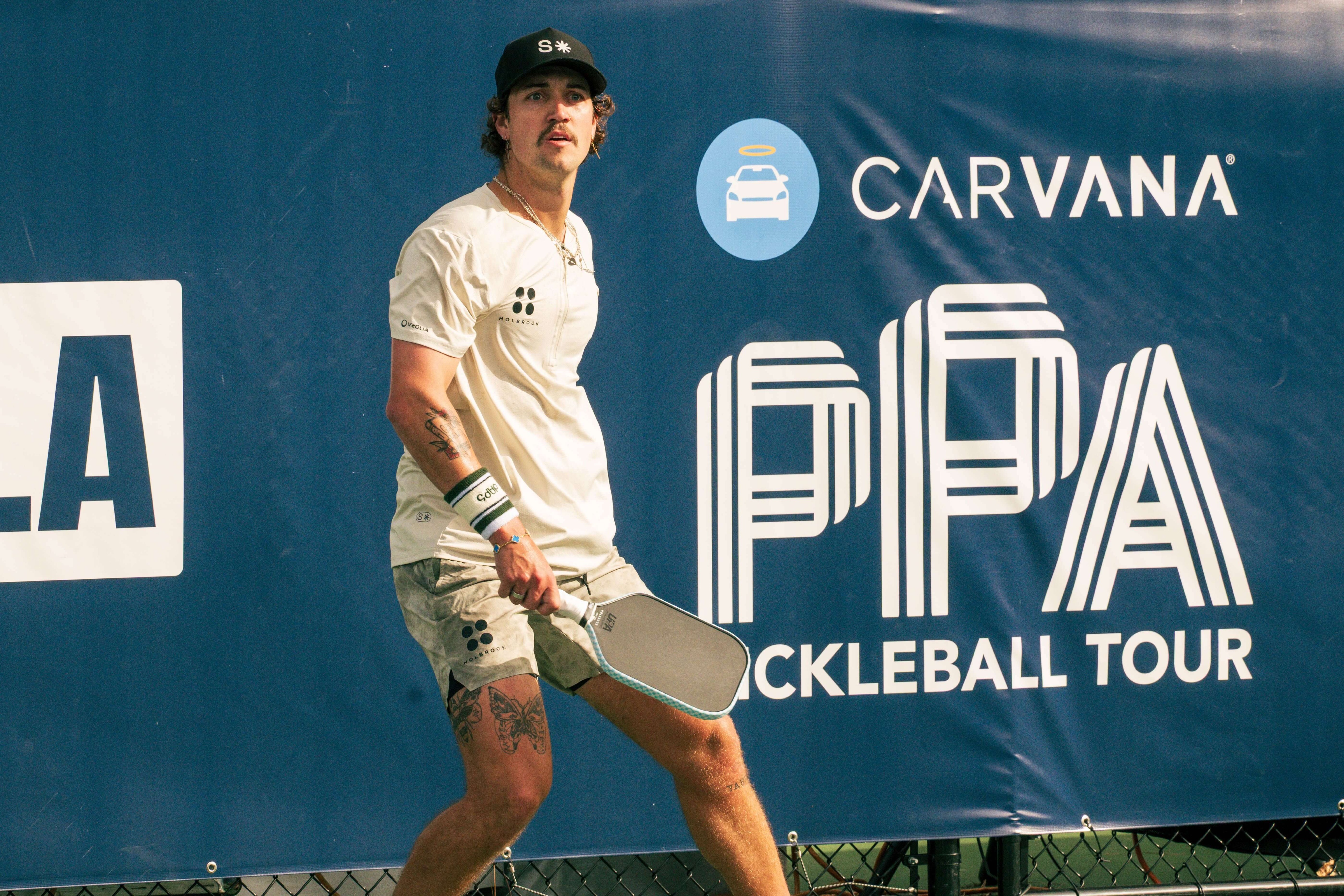 Loyd in cream shirt and green shorts